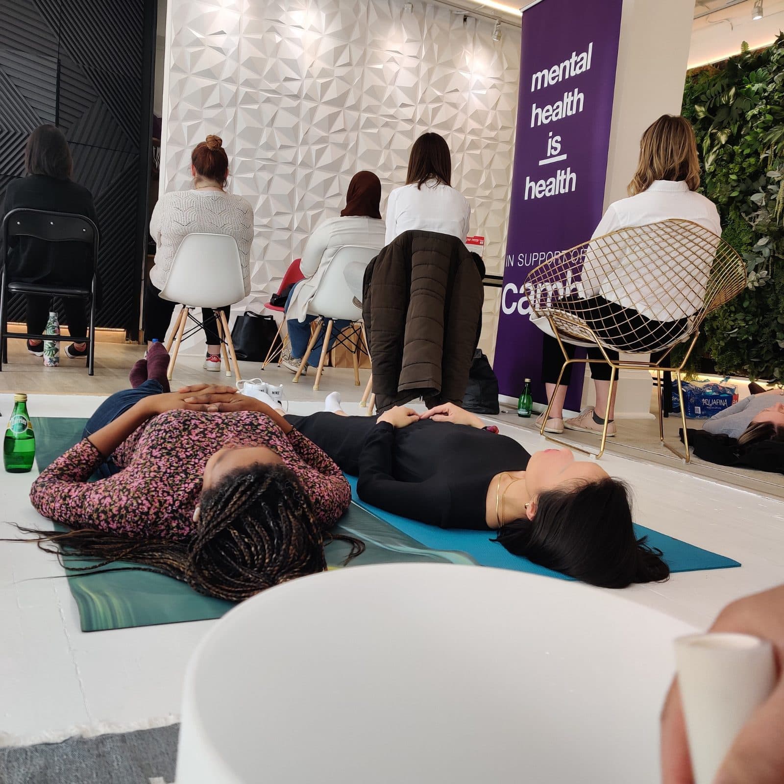 People lying down during a sound bath at CAMH under a banner reading mental health is health