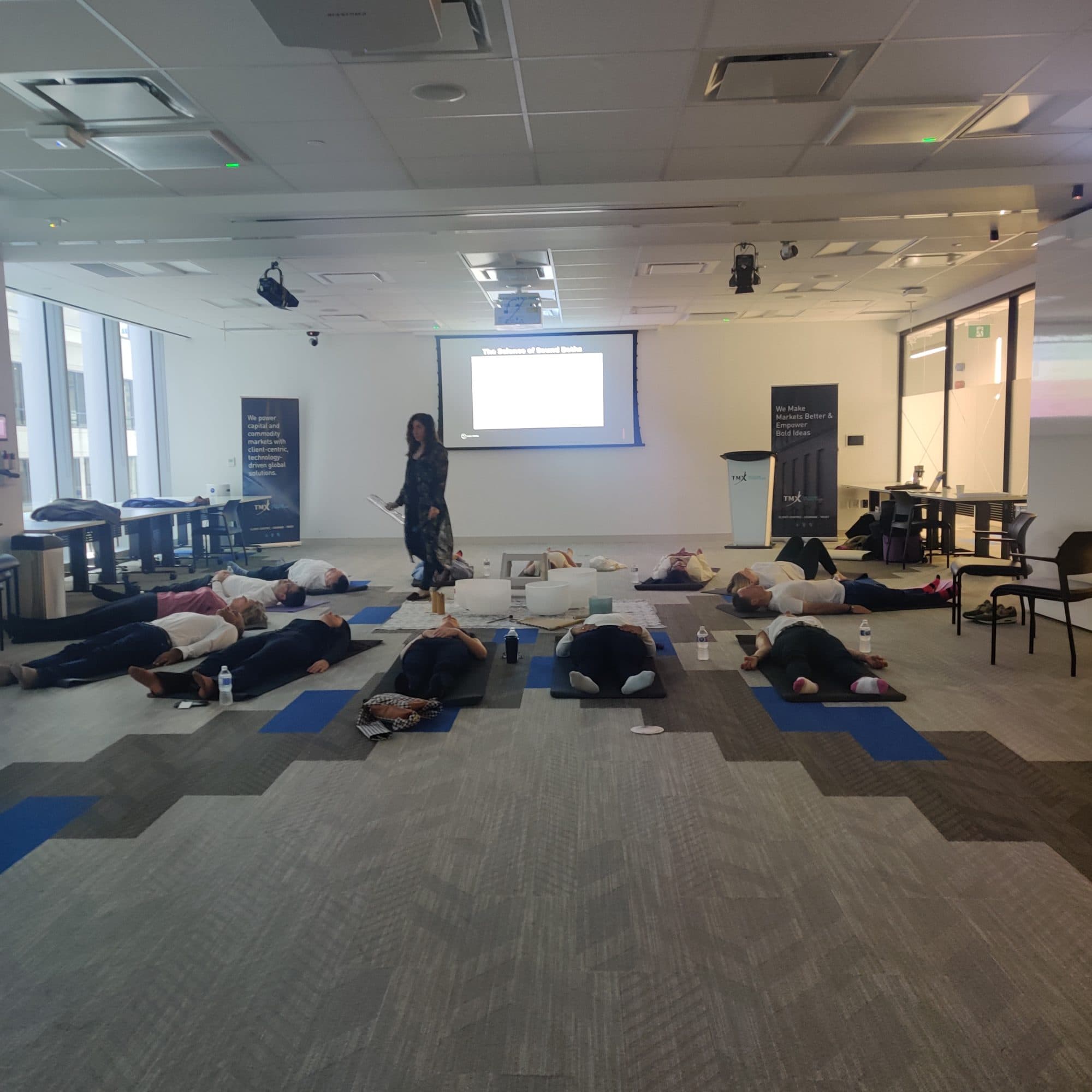 A room lying on mats during a sound bath at a head office in Toronto's Financial District